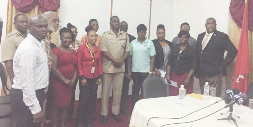 Commissioner of Police Leslie James (centre) with members of the Fallen Heroes Foundation and families who received donations on Friday. Also in photograph is Assistant Commissioner of Police Paul Williams (at left in the back row) 