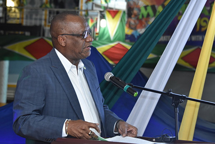 Minister of State Joseph Harmon delivering the feature address at the flag raising ceremony at the Linden Bus Park. (Ministry of the Presidency photo)
