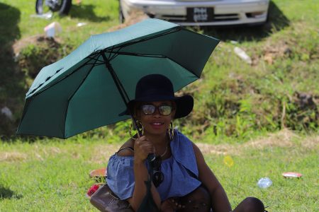 A mother sheltering her child from the blistering sun as they witnessed the Mash parade on Saturday.