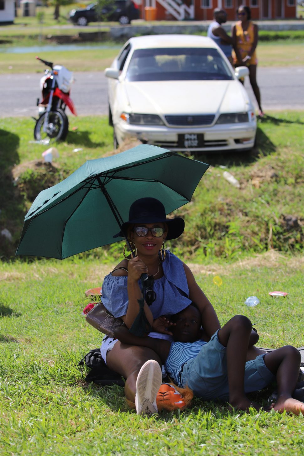 A mother sheltering her child from the blistering sun as they witnessed the Mash parade on Saturday.