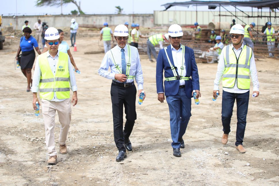 Representatives of CHEC guide Minister of Business Dominic Gaskin (second from left) and proprietor of the Pegasus Hotel,  Robert Badal (second from right) on a tour of the construction site of Pegaus Apartments and Corporate Suites.