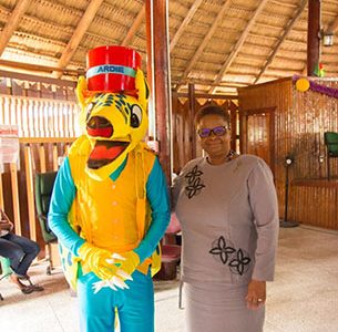 Minister of Public Health, Volda Lawrence shares a light moment with the Armadillo mascot  at the launch. (DPI photo)