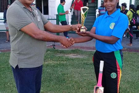 Lashana Toussaint receives her player of the match award from match referee Moses Ramnarine.