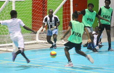 Shaquille Browne [left] of North East La Penitence uncorking a powerful shot at the Good Life goal during their clash at the National Gymnasium in the Magnum Mash Cup Futsal Championship