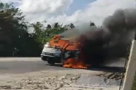 The minibus engulfed in smoke and flames