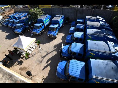 An aerial view of 11 of the 12 new trucks acquired by the Ministry of Local Government and Community Development to boost the capacity of the National Solid Waste Management Authority to handle garbage collection.