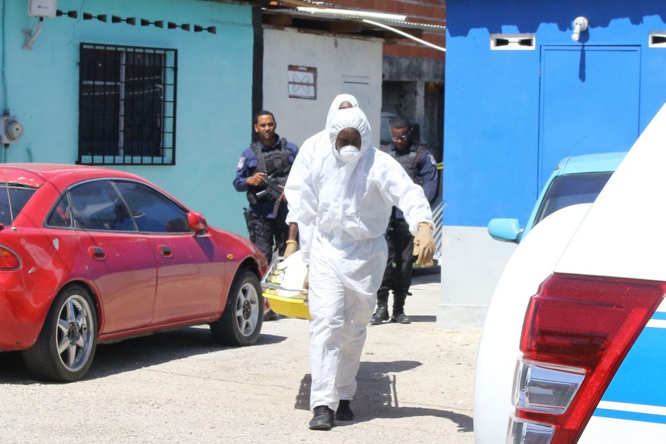 Undertakers remove the body of murder victim Nigel Francisco from his Sea Lots home yesterday.