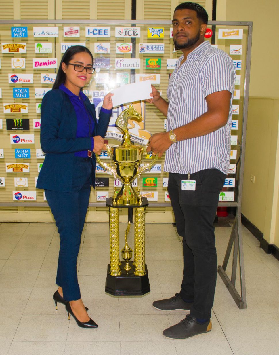 Organiser Nasrudeen Mohamed receives the sponsorship cheque from Banks DIH Limited’s Shenisa Fredericks.
