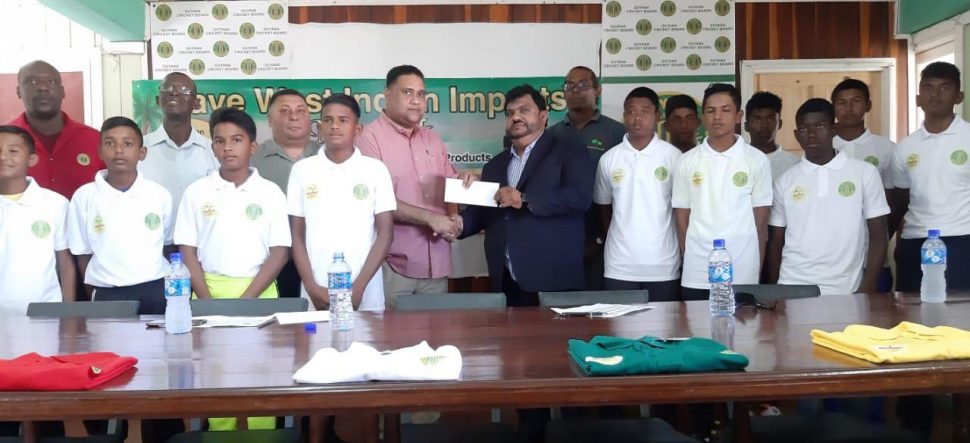 Dave Narine (right) hands over the sponsorship cheque of the 2019 GCB/Dave West Indian Imports Inter-County Under-15 tournament to Guyana Cricket Board’s Anand Kalladeen in the presence of some of the players and officials
