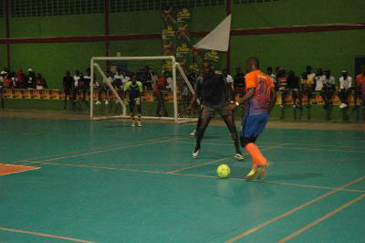Selwyn Williams [orange] of Back Circle attempting to dribble past Daniel Wilson of Bent Street during their semi-final clash at the National Gymnasium in the 2nd Annual/Magnum Mash Cup Futsal Championship
