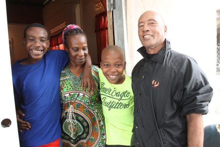 Happy to be alive, Darold Clarke, left and his brother Adeil Cyrus, are hugged by their mother Fredricka Hodge and stepfather stepfather Kenneth at their home yesterday.