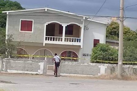 A policeman is about to enter the house of former People's National Party Councillor Marjorie “Madge” Morris in Yallahs, St Thomas where she was shot dead yesterday morning. 