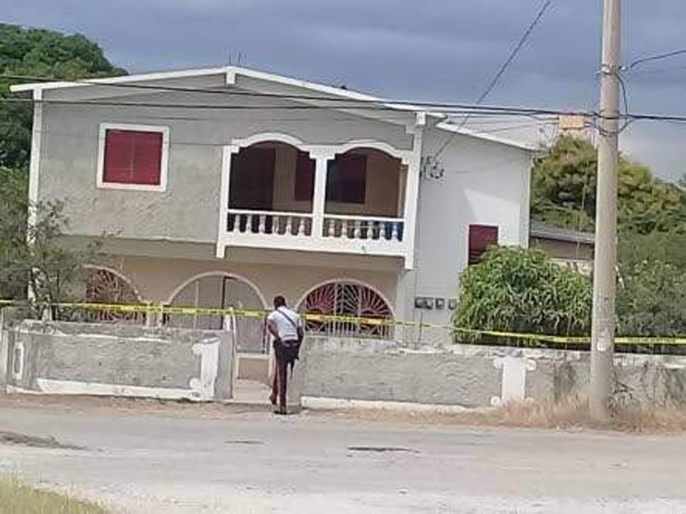 A policeman is about to enter the house of former People's National Party Councillor Marjorie “Madge” Morris in Yallahs, St Thomas where she was shot dead yesterday morning. 