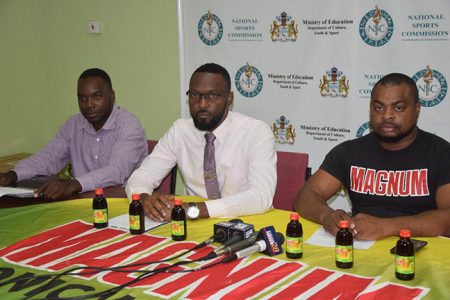 Director of Sports Christopher Jones [centre] addressing the gathering of media operatives on the 2nd NSC/Magnum Futsal Championship. Also in the photo are Magnum Brand Manager Edison Jefford [right] and tournament coordinator Esan Griffith