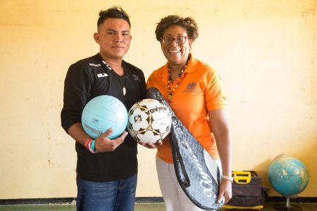 Minister of Public Telecommunications, Catherine Hughes presents sport gear to one of the residents. (DPI photo)