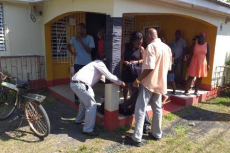 Former mayor of Port Antonio, Benny White, wraps a piece of black cloth around a post at the office of slain Eastern Portland Member of Parliament Dr Lynvale Bloomfield as a sign of mourning. Bloomfield’s body was found at his Passley Gardens home last Saturday morning with multiple stab wounds. Photo by Gareth Davis Sr