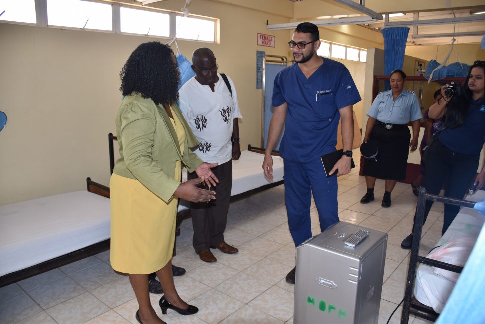 Minister within the Ministry of Public Health, Dr. Karen Cummings (left) being briefed on the uses of the oxygen concentrator. (DPI photo)