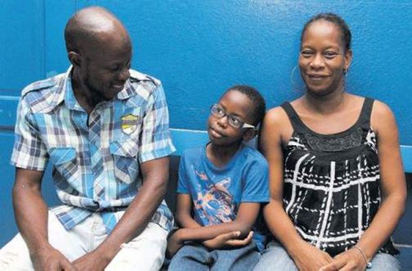 Suzzett Whyte and Sinclair Hutton with their first child, seven-year-old Rudeen, at the Denham Town Police Station yesterday. (Photo: Norman Thomas) 