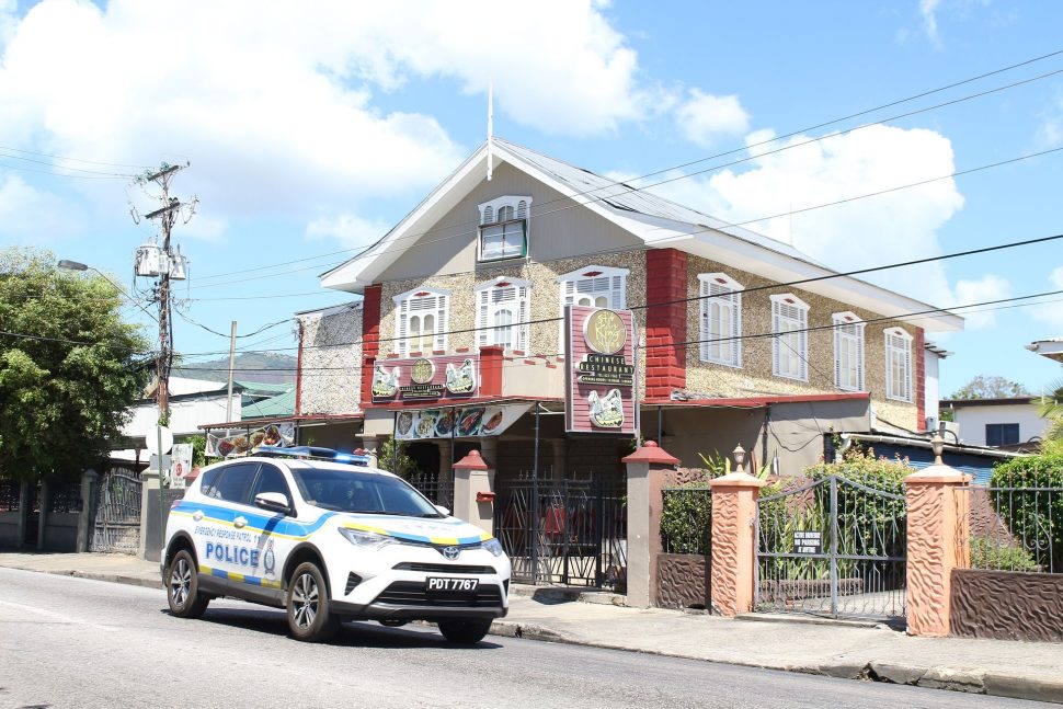 A police vehicle passes in front of Stir Fry Restaurant on Ariapita Avenue,  Woodbrook, hours after a raid at the establishment yesterday morning.
