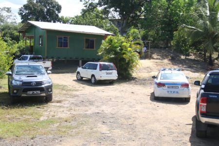 Police gather at a house in Gonzales Village, Point Fortin, where the body of an infant was discovered yesterday.