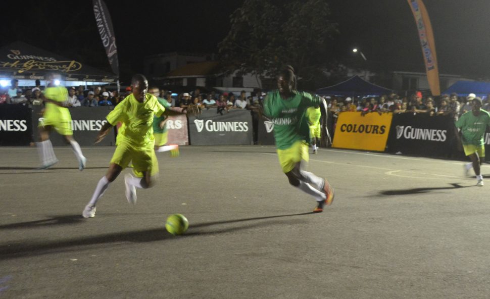 Flashback – Andrew Murray of Brothers United [dark green] and Jamal Hamilton of Ballers Empire and racing towards a loose ball during their semi-final clash at the Pouderoyen Tarmac in the Guinness ‘Greatest of the Streets’ West Demerara/East Bank Demerara Championship