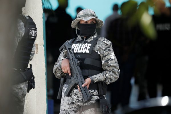 A SORT officer stands guard during a raid in Sea Lots earlier this week as part of the TTPS' attempt to rid the capital of gang violence.