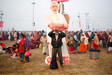 A devotee prays as he stands in front of a cutout of India’s Prime Minister Narendra Modi before taking a holy dip during “Kumbh Mela” or the Pitcher Festival, in Prayagraj, previously known as Allahabad, India, February 2, 2019. REUTERS/Adnan Abidi/File Photo