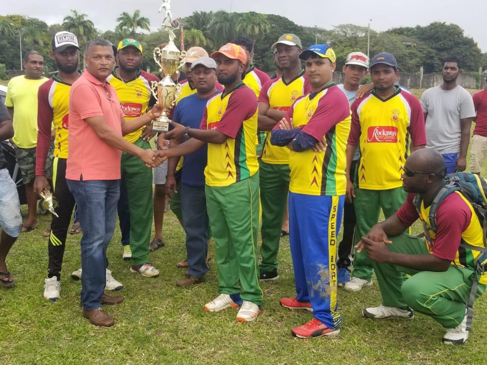 President of the West Demerara Cricket Association Anand Sanasie hands over the winning trophy to Independence A.
