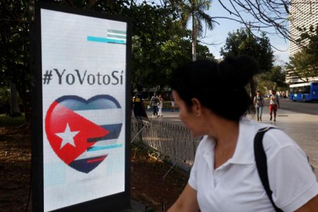 A woman passes by a screen displaying images promoting the vote for “yes” for the constitutional referendum, in Havana, Cuba, February 5, 2019. Picture taken on February 5, 2019. REUTERS/Stringer