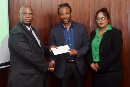 Region 10 Member of Parliament Jermaine Figueira (at centre) receives the approval letter from GNBA Chairman Leslie Sobers in the presence of Geeta Chandan-Edmond, who is the advisor to Minister of State Joseph Harmon. (GNBA photo) 