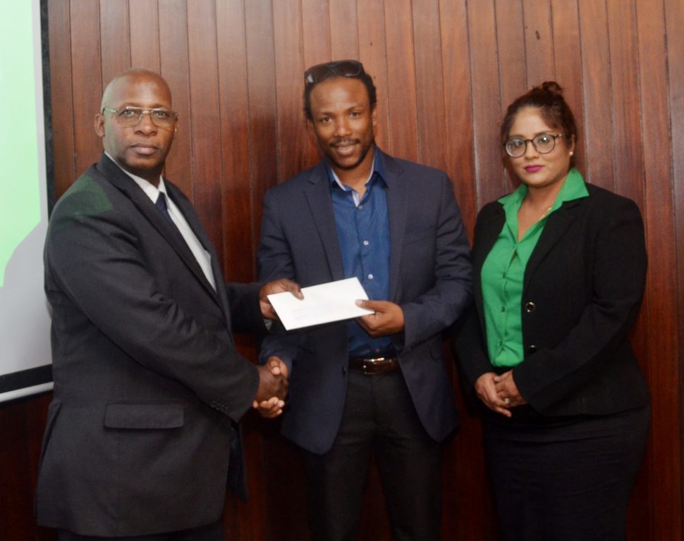 Region 10 Member of Parliament Jermaine Figueira (at centre) receives the approval letter from GNBA Chairman Leslie Sobers in the presence of Geeta Chandan-Edmond, who is the advisor to Minister of State Joseph Harmon. (GNBA photo) 