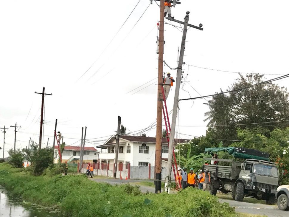 Employees of the Guyana Power and Light working to reconnect the power cables yesterday afternoon.