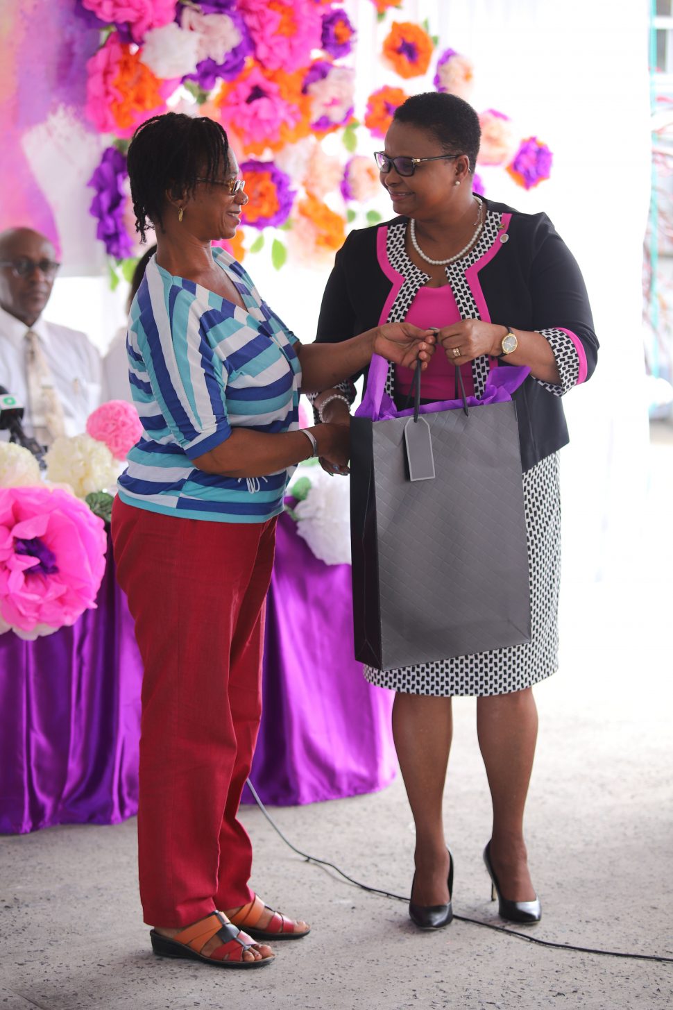 Minister of Public Health Volda Lawrence giving one of the auxiliary workers from the Ministry’s Maternal and Child Health Unit a care package yesterday afternoon for International Women’s Day. (Terrence Thompson photo)
