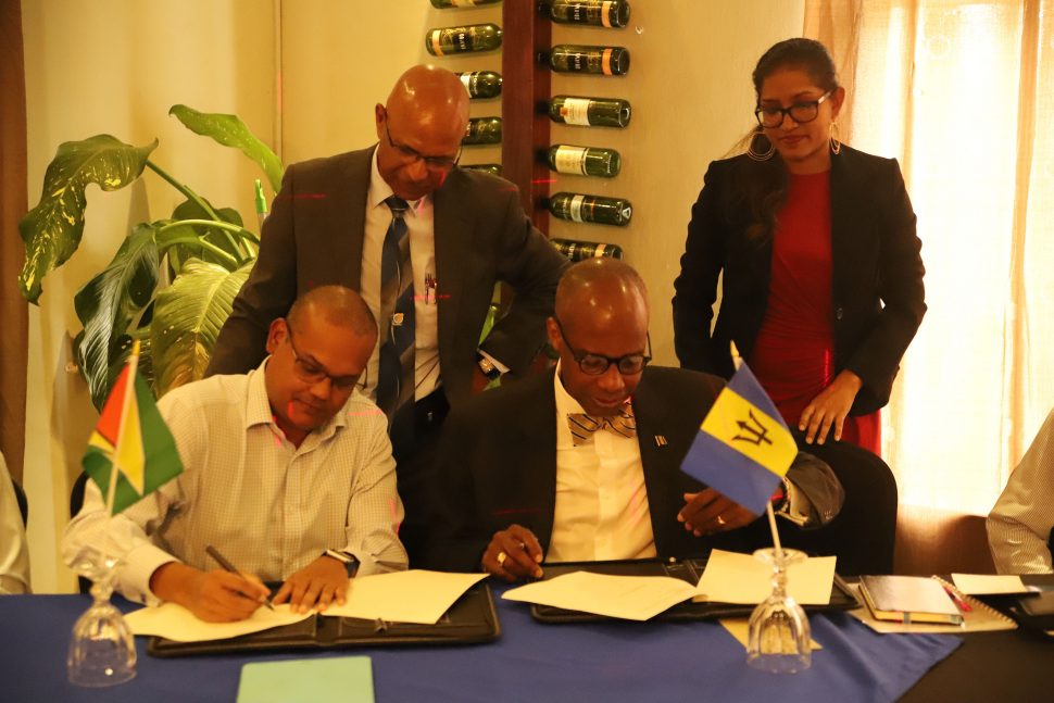 Chairman of the Guyana Association of Securities Companies and Intermediaries Nikhil Ramkarran (left) and Managing Director of the Barbados Stock Exchange Marlon Yarde (right), signing the Memorandum of Cooperation on Friday. (Terrence Thompson photo)