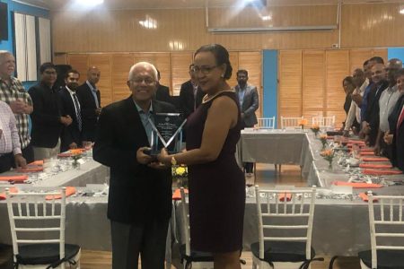 Outgoing Chairman of Massy Guyana Deo Persaud receiving the award from Executive Director of the Private Sector Commission Elizabeth Alleyne last night.
