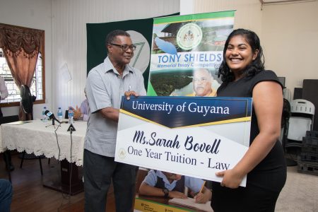 Sarah Bovell, winner in the University category of the Tony Shields Memorial Essay Competition, being awarded by Patrick Harding.  (Ministry of Natural Resources photo)