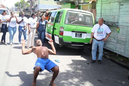 This Tiger Bay resident demonstrated his gymnastic abilities when Minister of Social Cohesion, Dr George Norton (right) visited the community on Saturday. He did a backflip and a handstand and was congratulated by the minister. (Terrence Thompson photo)