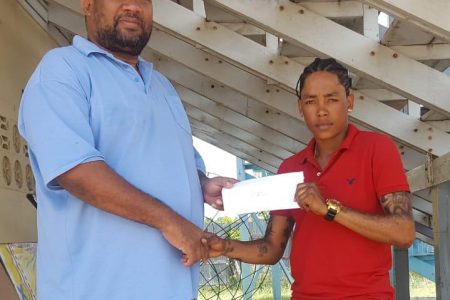 BCB President Hilbert Foster hands over the stipends to Guyana Captain Shemaine Campbelle.

