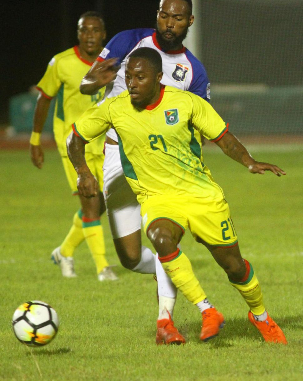 Golden Jaguars winger Callum Harriot [no.21] trying to maintain possession of the ball while being marked by a Belizean at the National Track and Field Centre, Leonora in the CONCACAF Nations League Qualifiers 