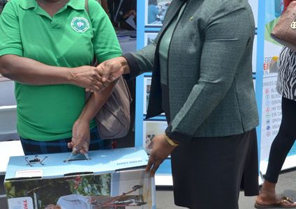 Doreen Williams (left) receives the wheelchair for her son from Minister within the Ministry of Public Health Dr. Karen Cummings (DPI photo)