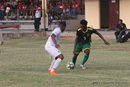 Guyana’s Kelsey Benjamin [no.7] trying to get past his Surinamese marker during their clash in an international friendly  at the Pierkhan Stadium, Nickerie, Suriname