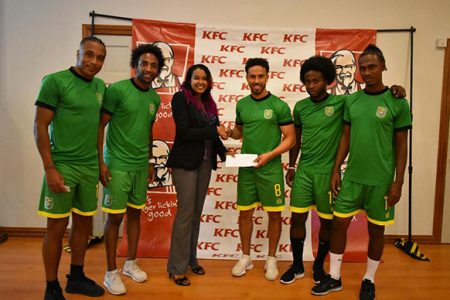 KFC’s Training Manager Charissa Rampersaud [center] handing over the company’s sponsorship cheque to Golden Jaguars captain Sam Cook in the presence of team-mates [from to left]-Neil Danns, Walter Moore, Trayon Bobb and Gregory Richardson