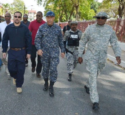 police presence: Commissioner of Police Gary Griffith, centre, in camouflage with members of the police service walks on Abercromby Street, Port of Spain on Carnival Tuesday. At left is National Security Minister Stuart Young. —Photo: ISHMAEL SALANDY