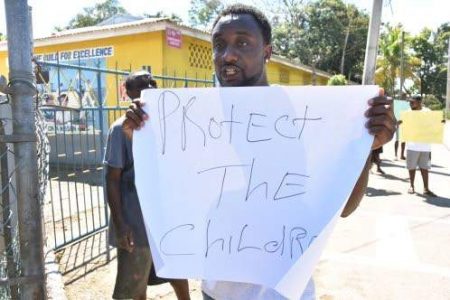 Dalvern Douglas, father of an injured Victoria Primary School student, protests outside the institution yesterday. 