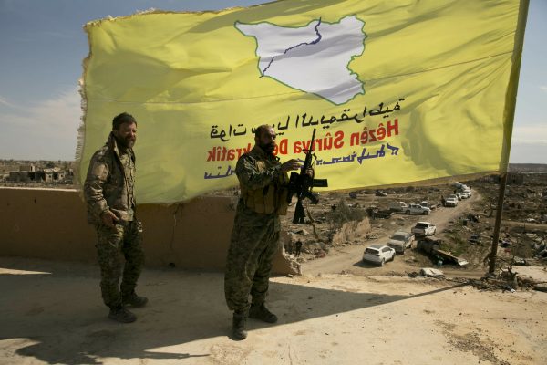 U.S.-backed Syrian Democratic Forces (SDF) fighters pose for a photo on a rooftop overlooking Baghouz, Syria (AP Photo/Maya Alleruzzo)