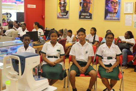 Students waiting to receive their free spectacles at the Courts Optical Main Street branch yesterday. (Photo by Terrence Thompson)