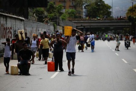 Venezuelans carry buckets filled with water. A power outage that began on March 7 left much of the capital, Caracas, without electricity, running water or public transportation for days. Reuters/Carlos Garcia Rawlins