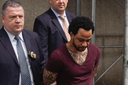 Troy Thomas, the suspect in a 2011 Queens murder, is pictured being escorted from 109th Precinct in Queens on Thursday. (Go Nakamura/for New York Daily News)