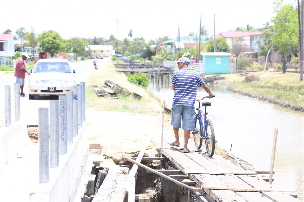 One of the residents who had to dismount his bicycle to traverse the unsafe bridge 

