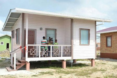 Ayasia LaFleur and four of her children standing on the veranda of their new home after the handing over ceremony at the New Prospect Housing Scheme yesterday. (Department of Public Information photo) 